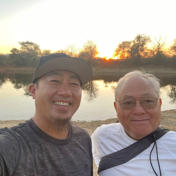 Maui and Dad smiling by a lake at sunset